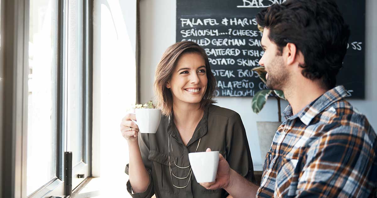 Young couple enjoying a cup of coffee while sitting in a coffee shop